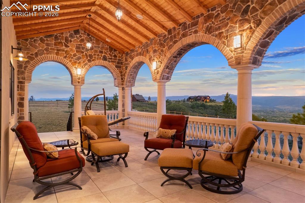 Image 6 of 39: Covered deck with stone arches, tongue-and-groove ceiling, and unobstructed
