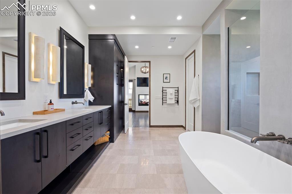Image 9 of 39: Spa-inspired primary bath with freestanding soaking tub, dual vanities, tow