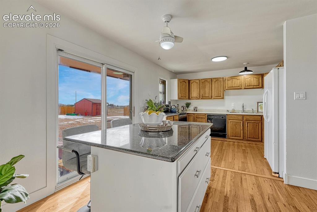 Image 15 of 42: Kitchen on the south side of the house. Granite toped island and sliders to