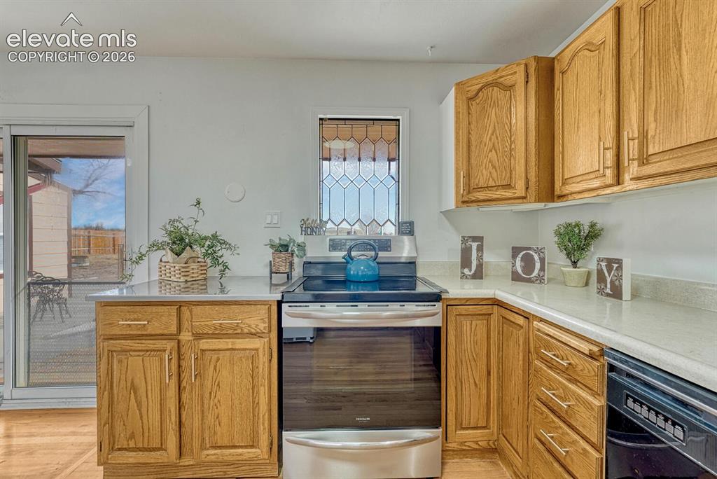 Image 19 of 42: Kitchen with leaded glass window, sliders to backyard on the left