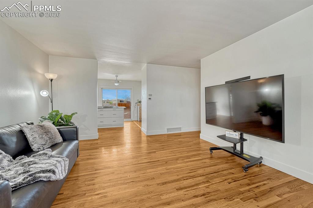 Image 26 of 42: Living room, opens to kitchen with walkout to backyard.