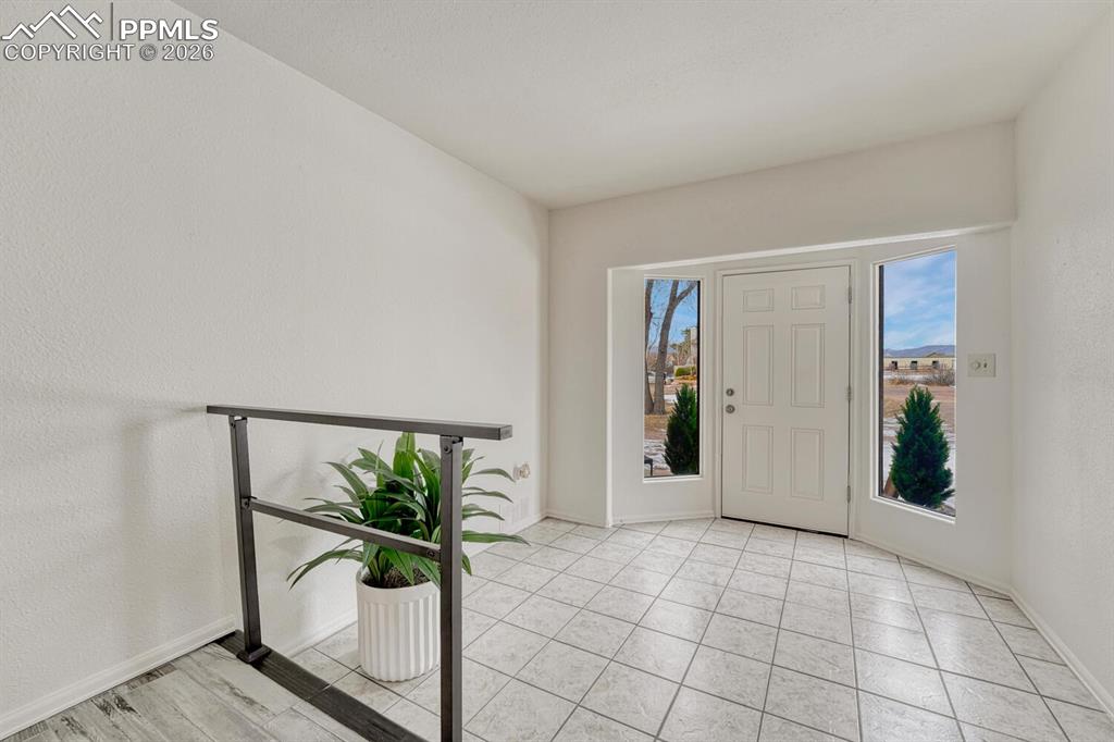 Image 3 of 42: One of the 2 front entrances, with a large tile foyer and window panels for
