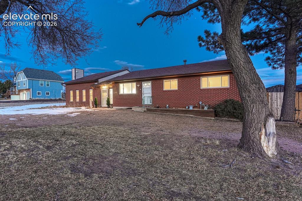 Image 3 of 42: Brick fronted home with lots of west facing windows and sweeping front ranc