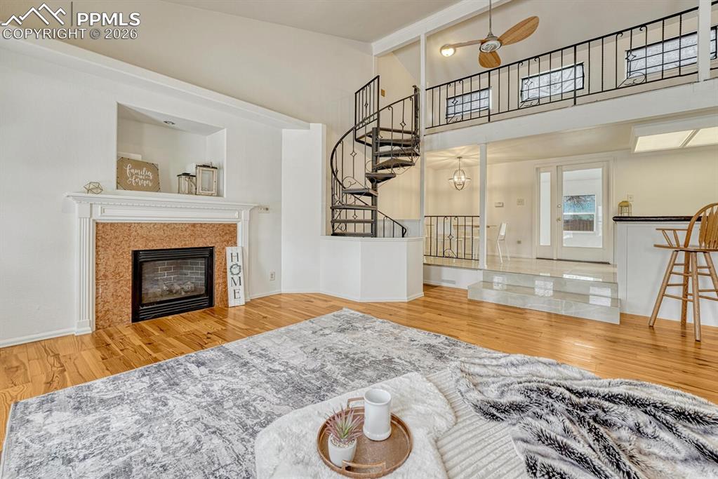 Image 7 of 42: Living room with view of spiral staircase to loft, wet bar and dining area 