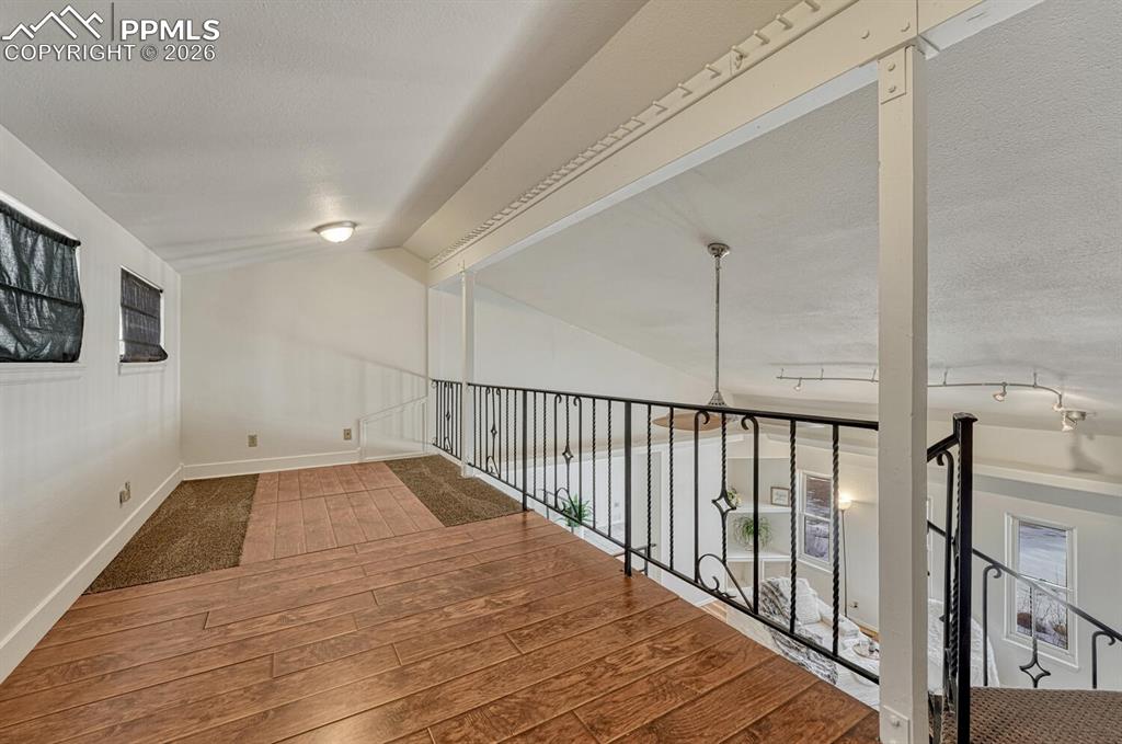 Image 8 of 42: loft above living room. Game zone, library, office, craft corner? Tons of p