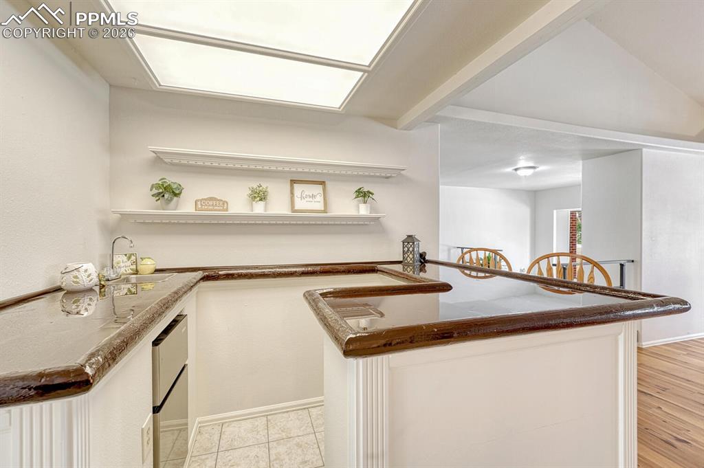 Image 9 of 42: Wet bar with small fridge and sink