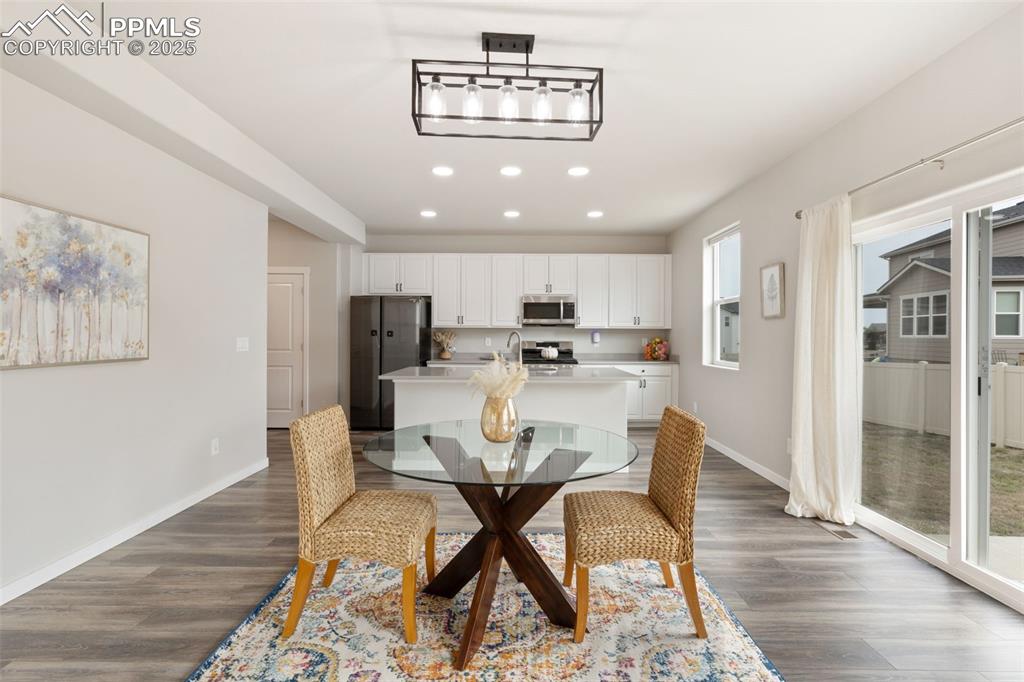 Image 10 of 26: Dining area with recessed lighting and dark wood-style flooring