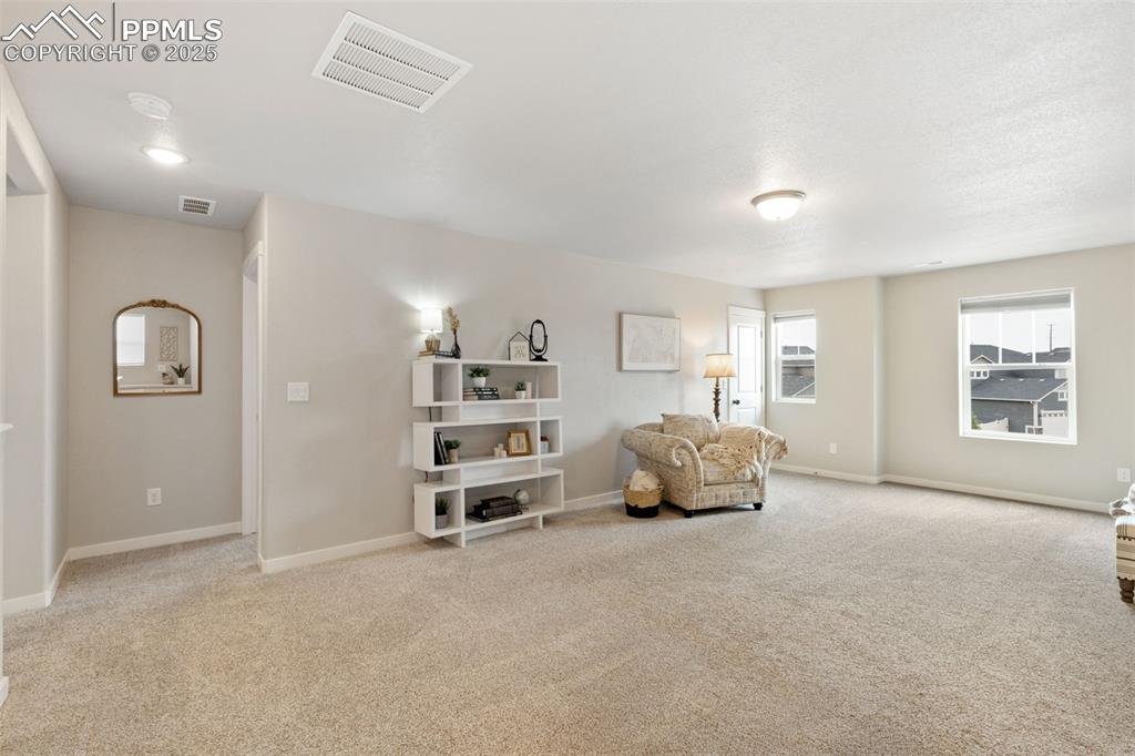 Image 13 of 26: Living area with light carpet