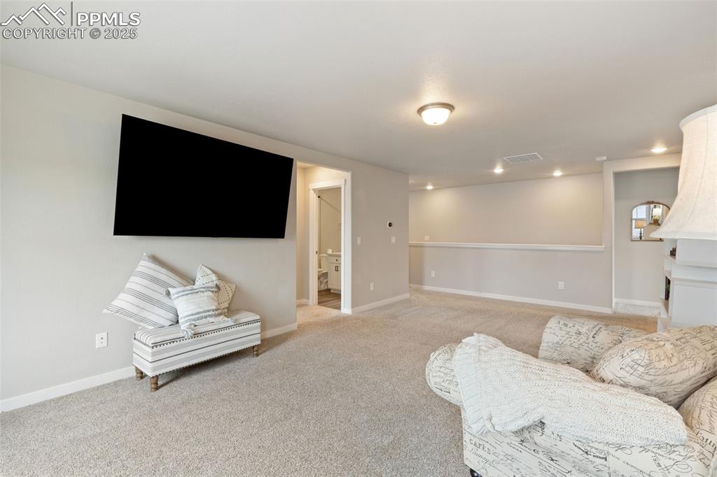 Image 14 of 26: Living area featuring light carpet and baseboards
