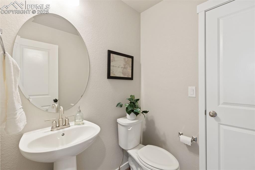 Image 15 of 26: Bathroom featuring a textured wall and toilet