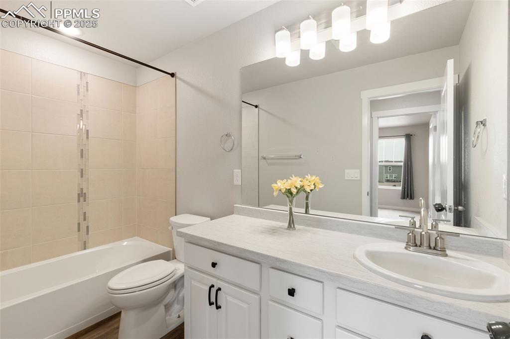 Image 22 of 26: Full bath with tub / shower combination, vanity, and dark wood-style floori
