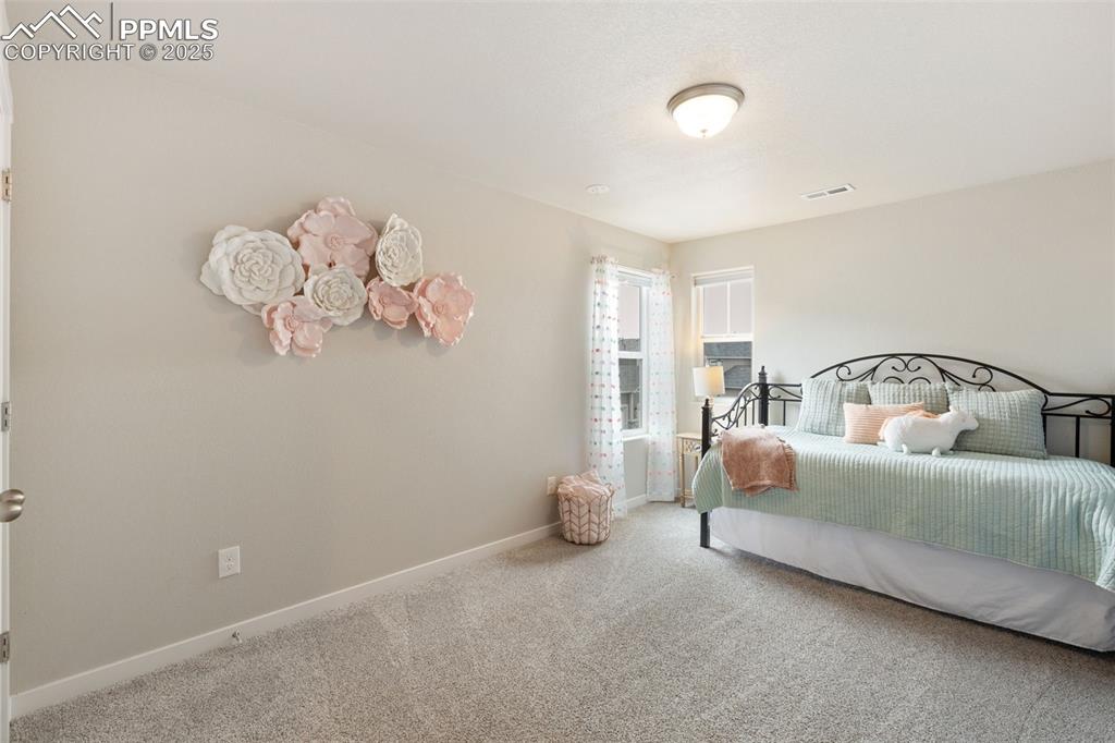 Image 23 of 26: Bedroom with carpet floors and baseboards