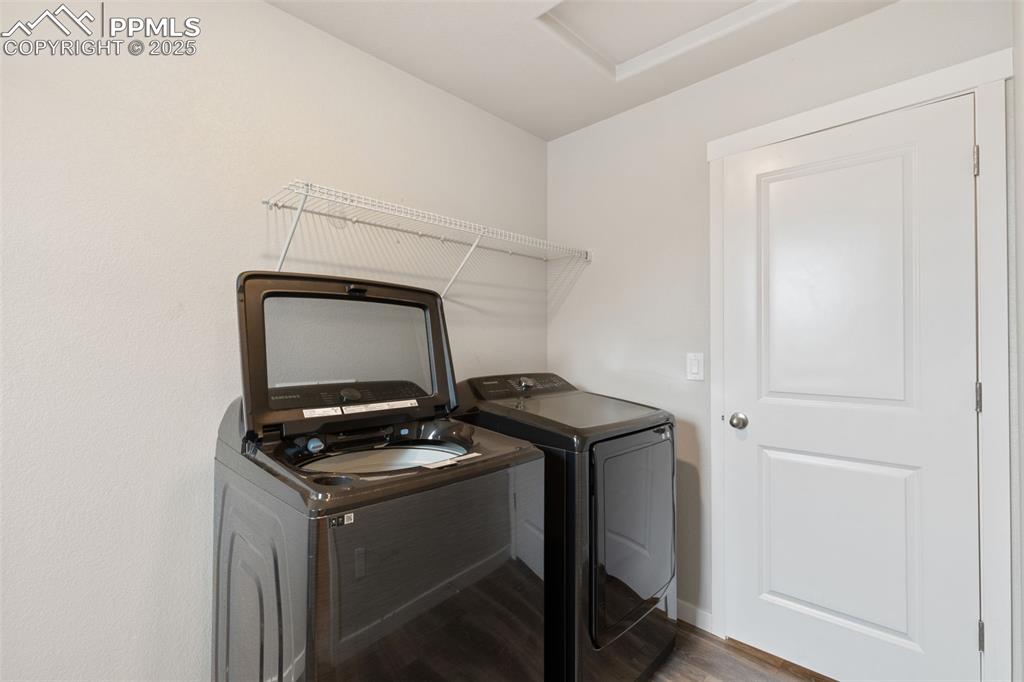 Image 24 of 26: Laundry area with wood finished floors and washer and clothes dryer