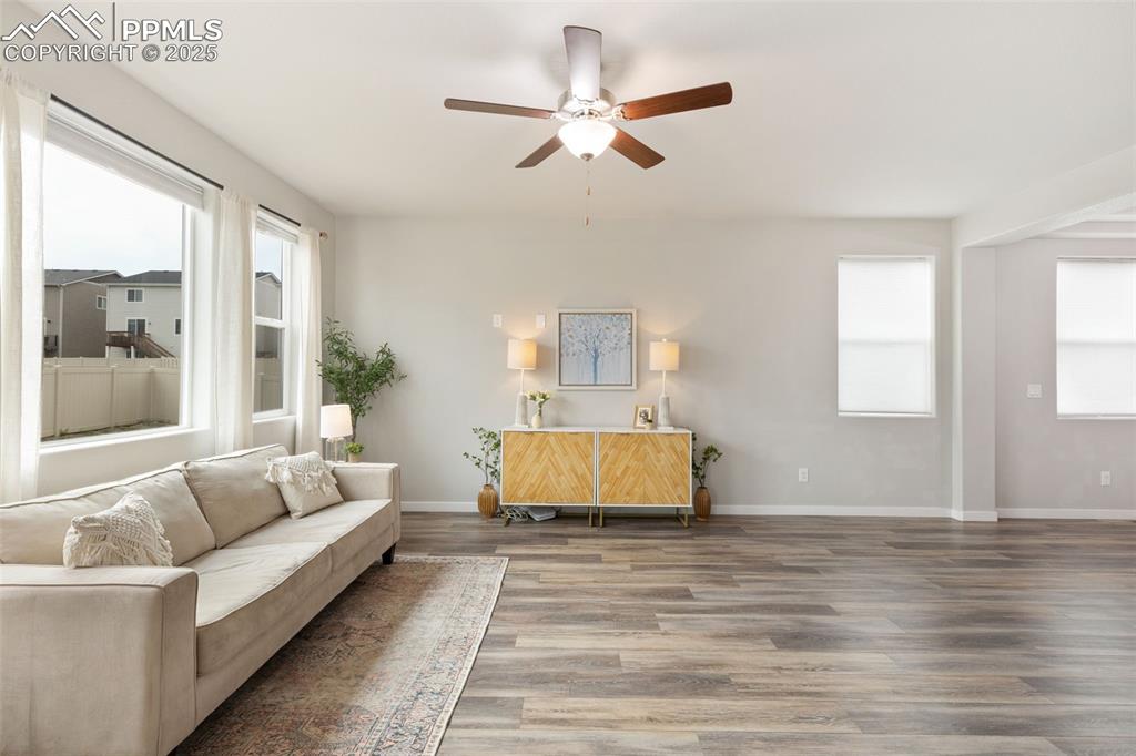 Image 6 of 26: Living area with wood finished floors and ceiling fan
