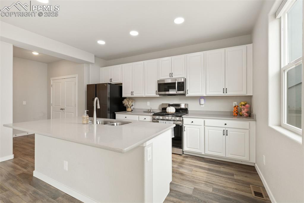 Image 7 of 26: Kitchen featuring stainless steel appliances, white cabinets, recessed ligh