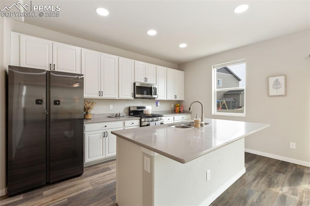 Image 8 of 26: Kitchen with appliances with stainless steel finishes, white cabinetry, a k