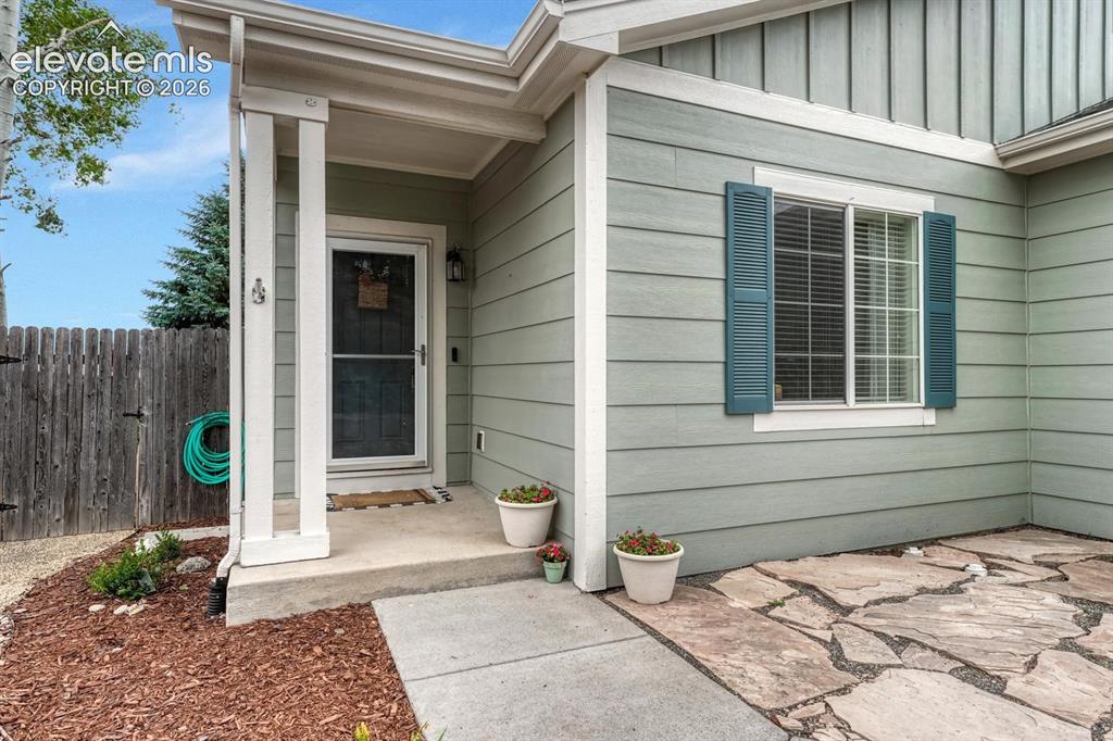 Image 12 of 50: Covered front porch and flagstone patio.