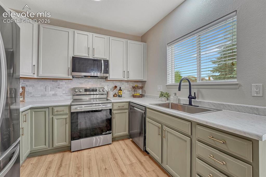 Image 19 of 50: Appliances include a smooth top range oven, built-in microwave oven, dishwa