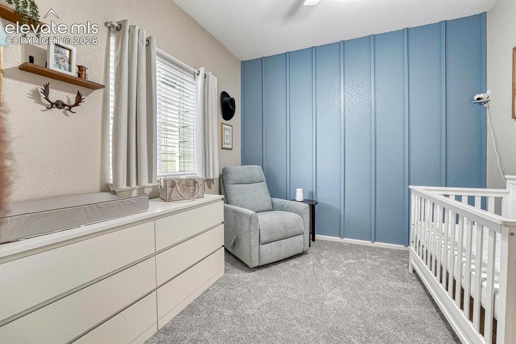 Image 28 of 50: Main Level Bedroom #3 with neutral carpet, lighted ceiling fan, and accent