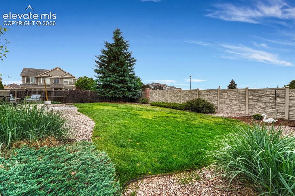 Image 44 of 50: Beautifully landscaped backyard with backyard sprinkler system.