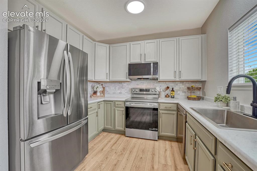 Image 6 of 50: The bright kitchen is inviting & practical, offering ample wood cabinetry,