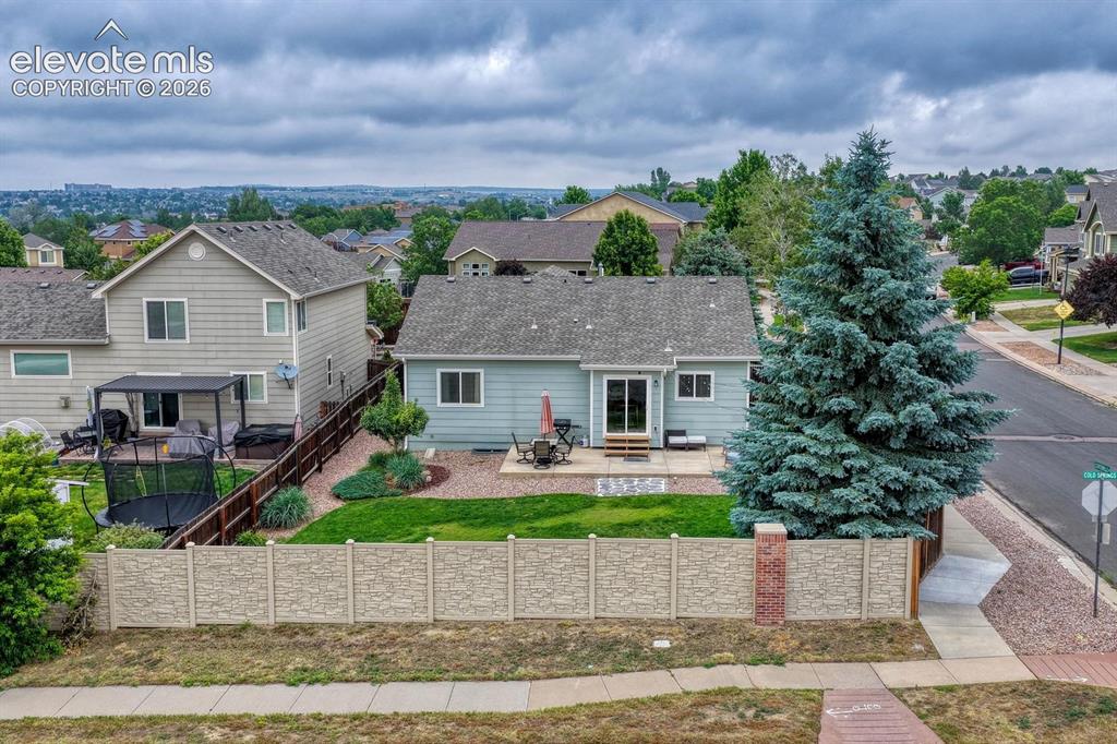 Image 9 of 50: Aerial rear view of home and fenced backyard.