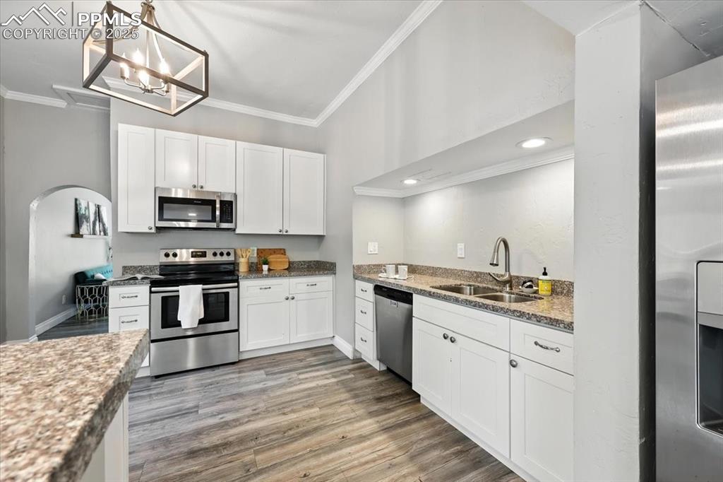 Image 13 of 36: Kitchen with crown molding, appliances with stainless steel finishes, light