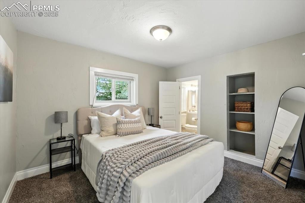 Image 15 of 36: Bedroom with dark colored carpet and ensuite bath