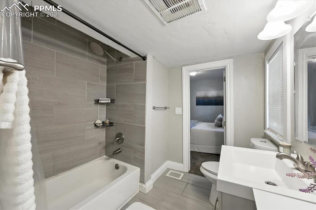Image 18 of 36: Ensuite bathroom with shower / tub combo and vanity
