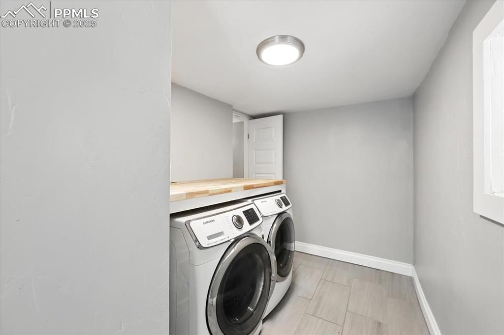 Image 19 of 36: Laundry area featuring washing machine and dryer and baseboards