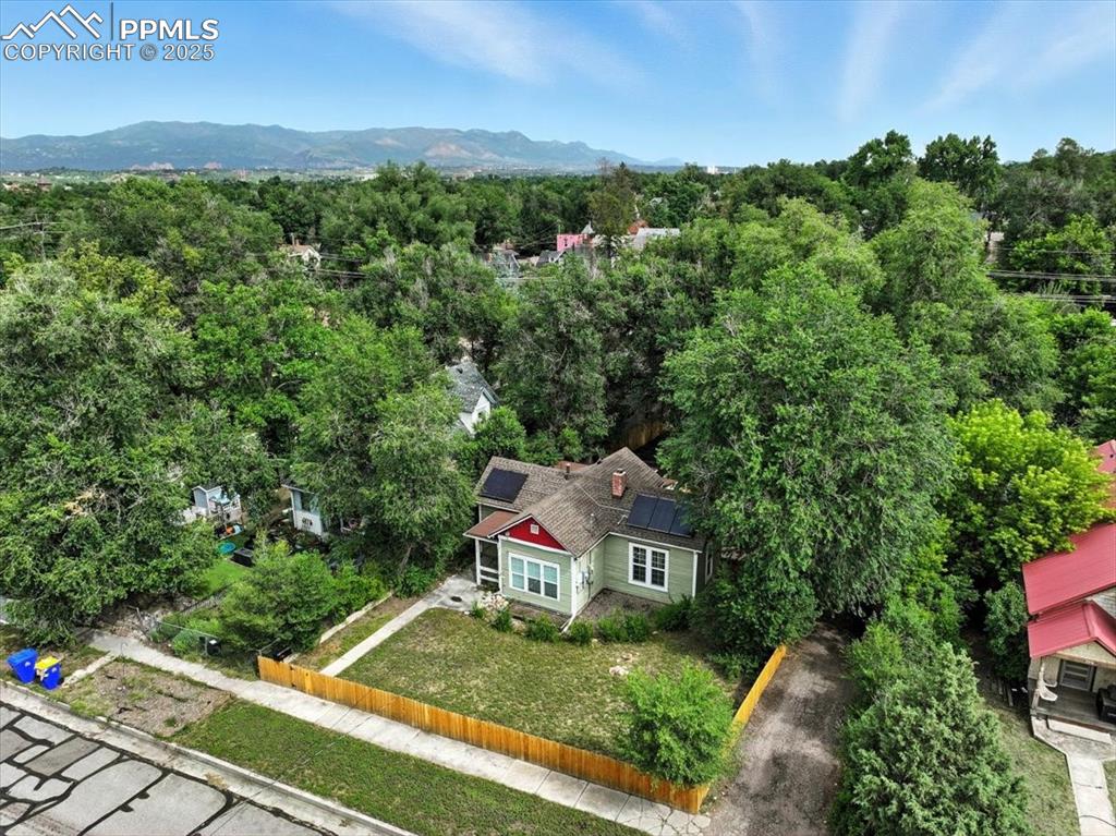 Image 2 of 36: View from above of property with a forest and mountains