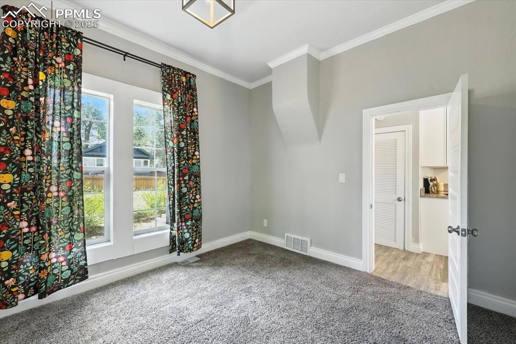 Image 23 of 36: Unfurnished room featuring carpet flooring and crown molding