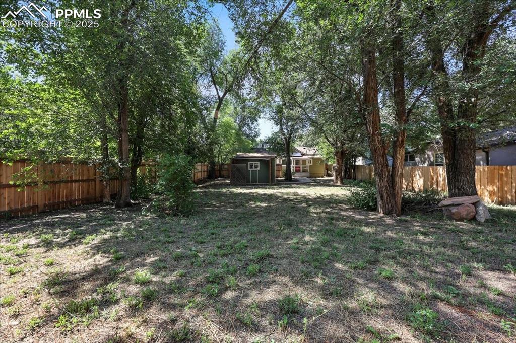 Image 32 of 36: Fenced backyard with a storage shed