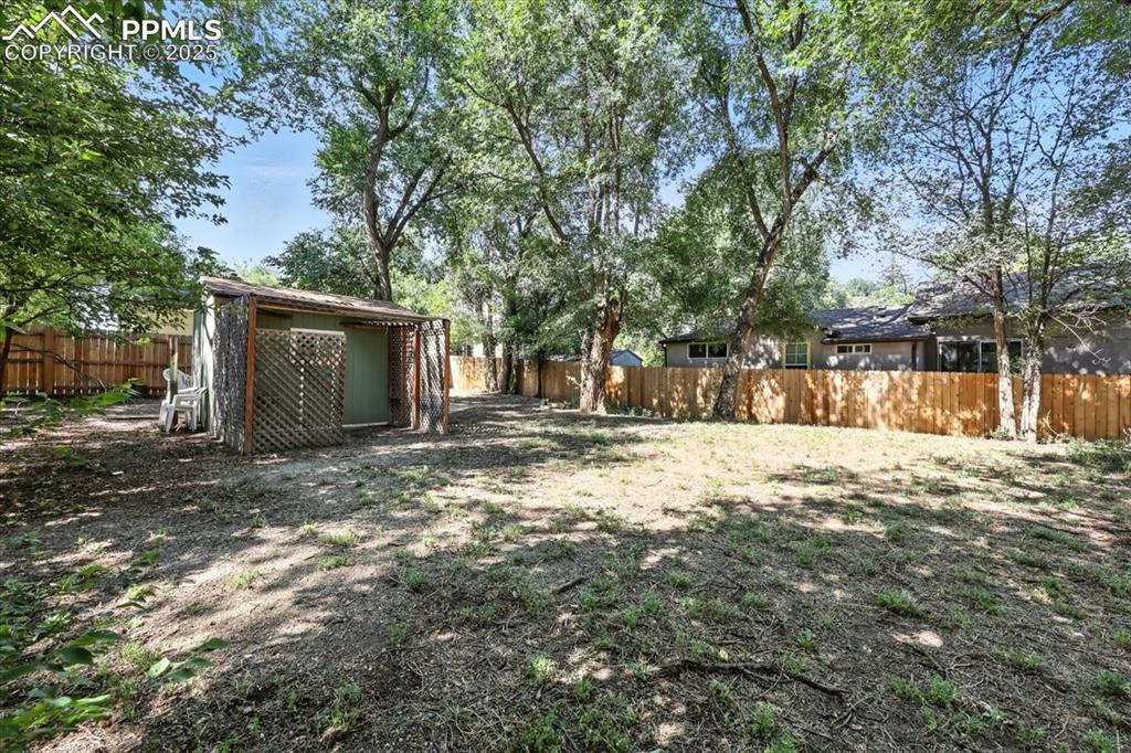 Image 36 of 36: Fenced backyard with an outbuilding