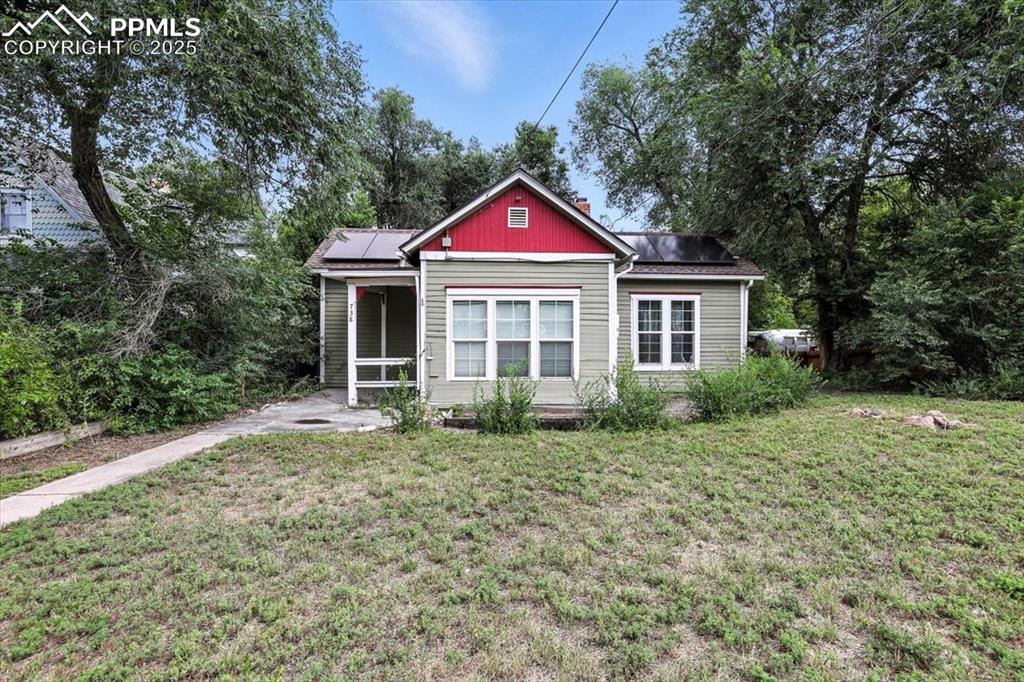 Image 5 of 36: Bungalow-style house featuring solar panels and a front yard