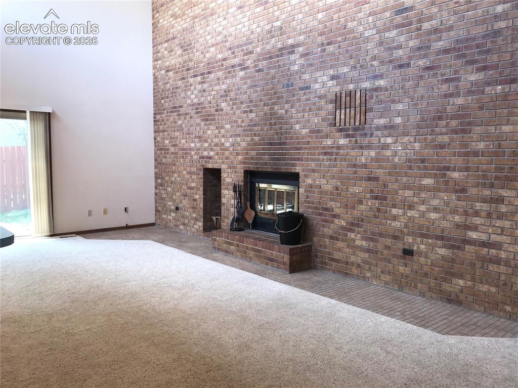 Image 10 of 35: Vaulted ceiling living space featuring a floor-to-ceiling brick fireplace w