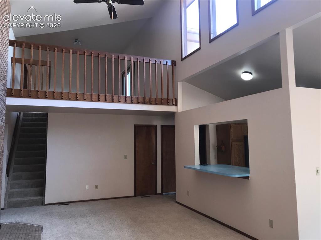Image 13 of 35: Vaulted ceilings with high windows, an interior balcony with wood railing, 