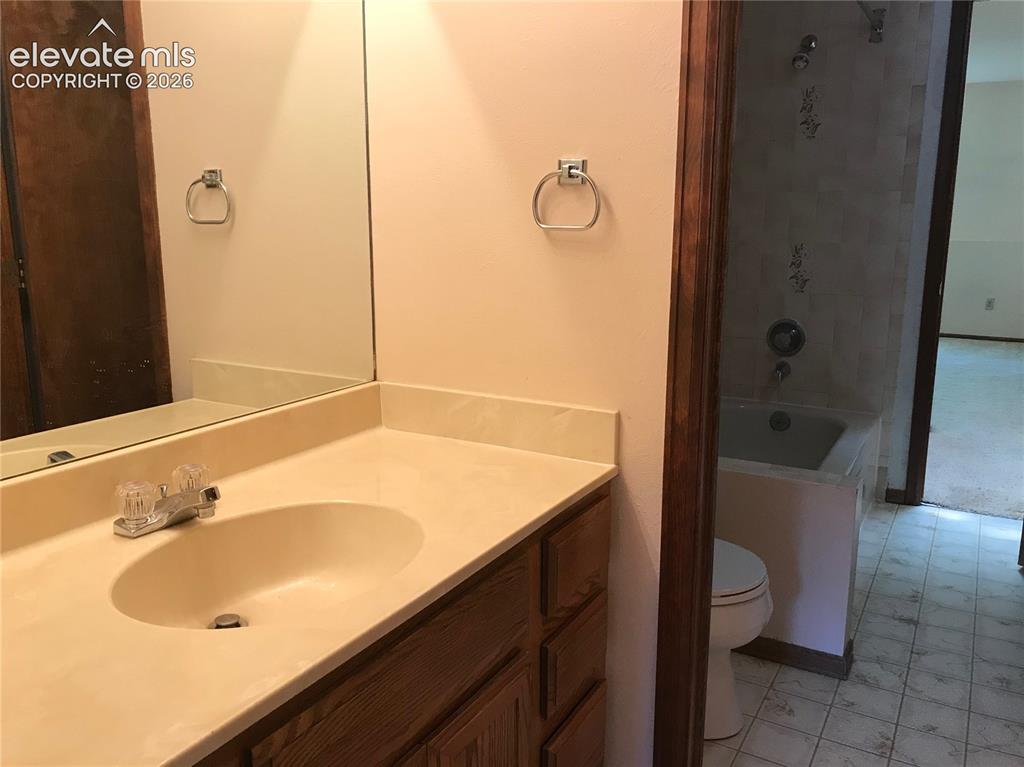 Image 19 of 35: Bathroom vanity featuring an integrated sink, laminate countertop, and wood