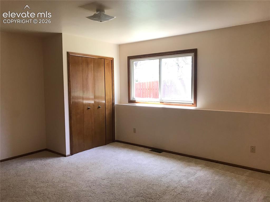 Image 20 of 35: Carpeted interior space featuring a double-pane window with wood trim, a bu