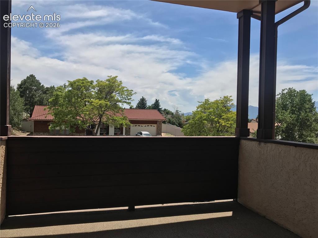 Image 26 of 35: Outdoor patio space with privacy wall, stucco exterior, and overhead coveri