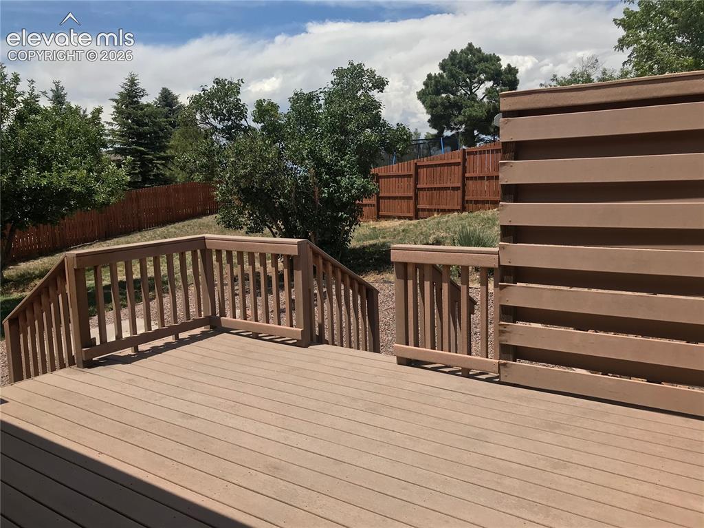 Image 30 of 35: Expansive outdoor deck featuring wood-finish decking and railings, with a s