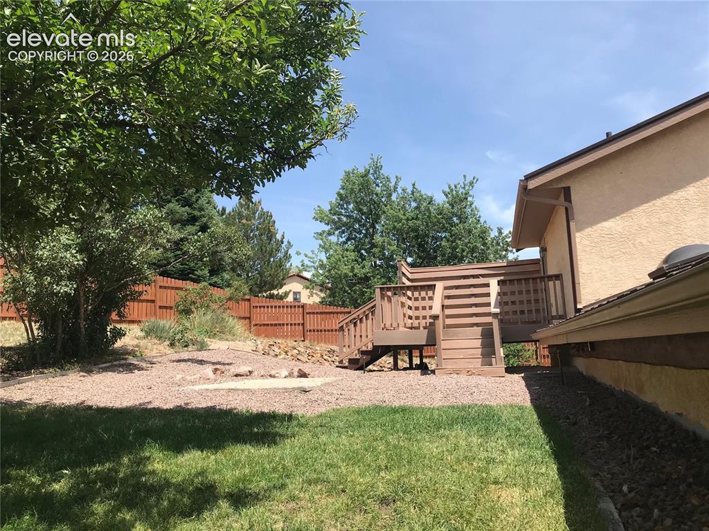Image 33 of 35: Expansive backyard featuring a multi-level wooden deck, a dedicated fire pi