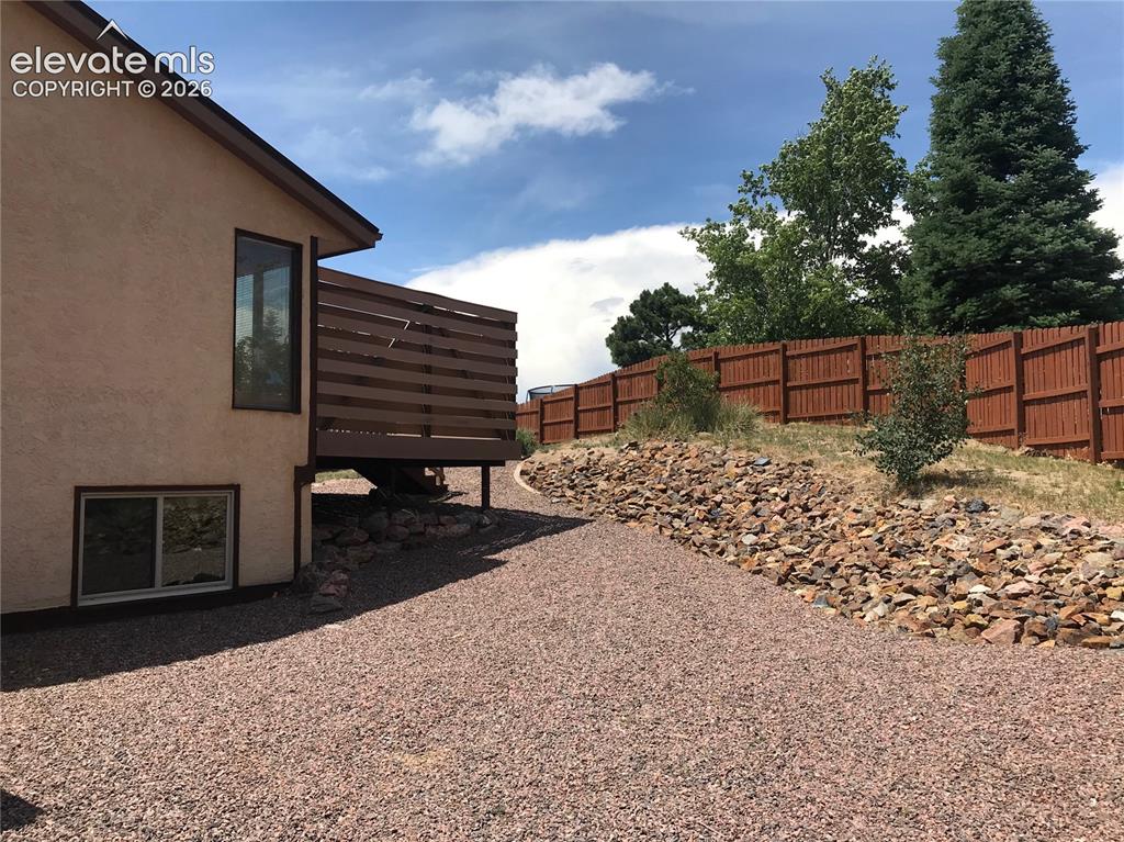 Image 34 of 35: Exterior stucco finish with a private deck featuring horizontal wood railin