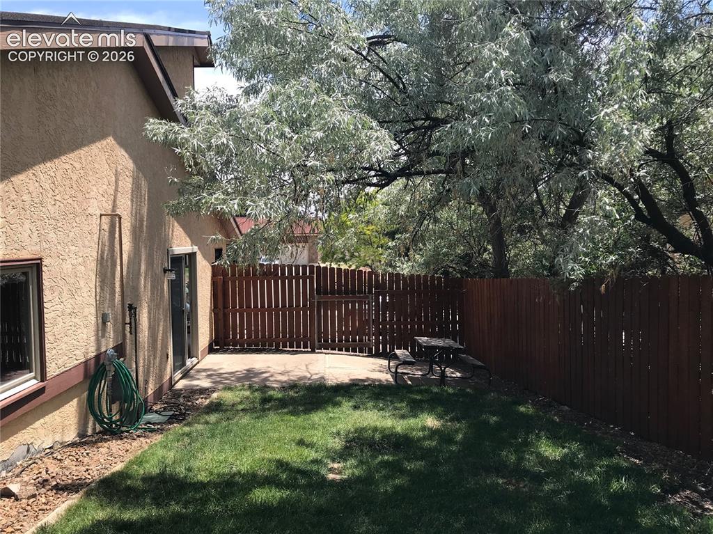 Image 35 of 35: Private backyard featuring a concrete patio, wood privacy fencing, and matu