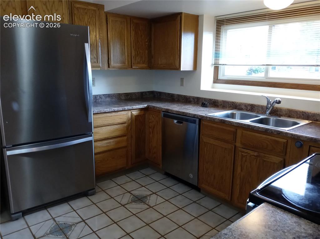 Image 4 of 35: Kitchen featuring wood cabinetry, stainless steel refrigerator and dishwash