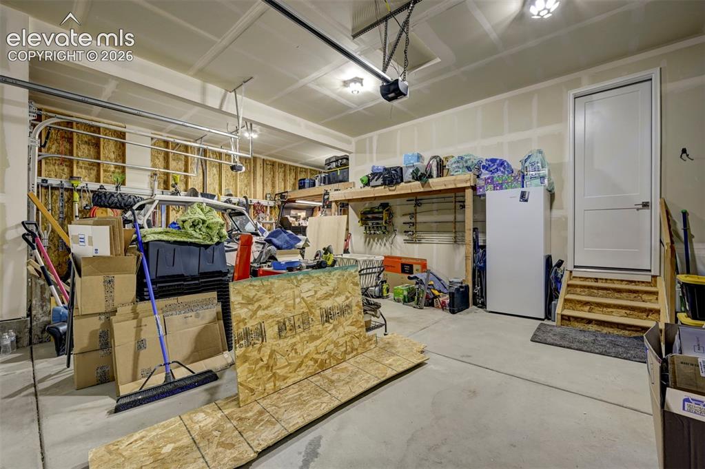 Image 15 of 47: 3-Car Tandem Garage with overhead shelving