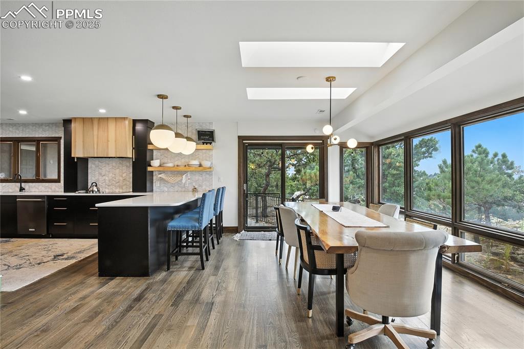 Image 15 of 50: Dining room featuring dark wood finished floors, a chandelier, a skylight, 