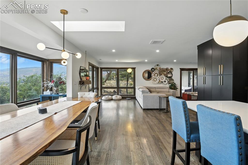 Image 18 of 50: Dining room with a skylight, dark wood finished floors, and recessed lighti