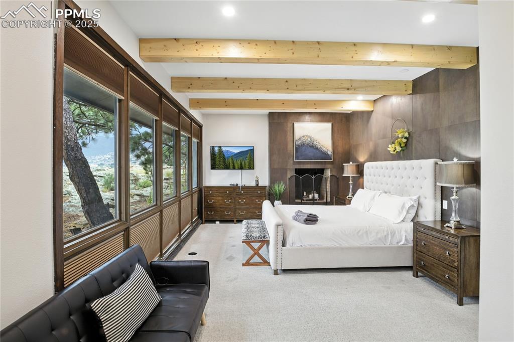 Image 24 of 50: Bedroom with beam ceiling and light colored carpet