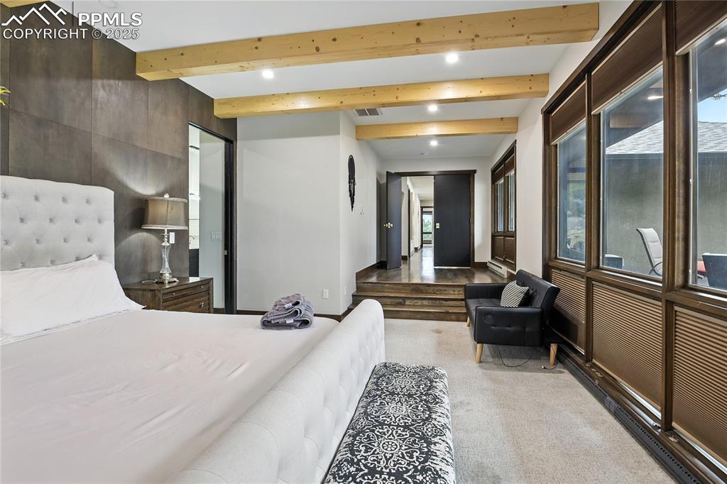 Image 26 of 50: Bedroom featuring beamed ceiling, light colored carpet, and recessed lighti